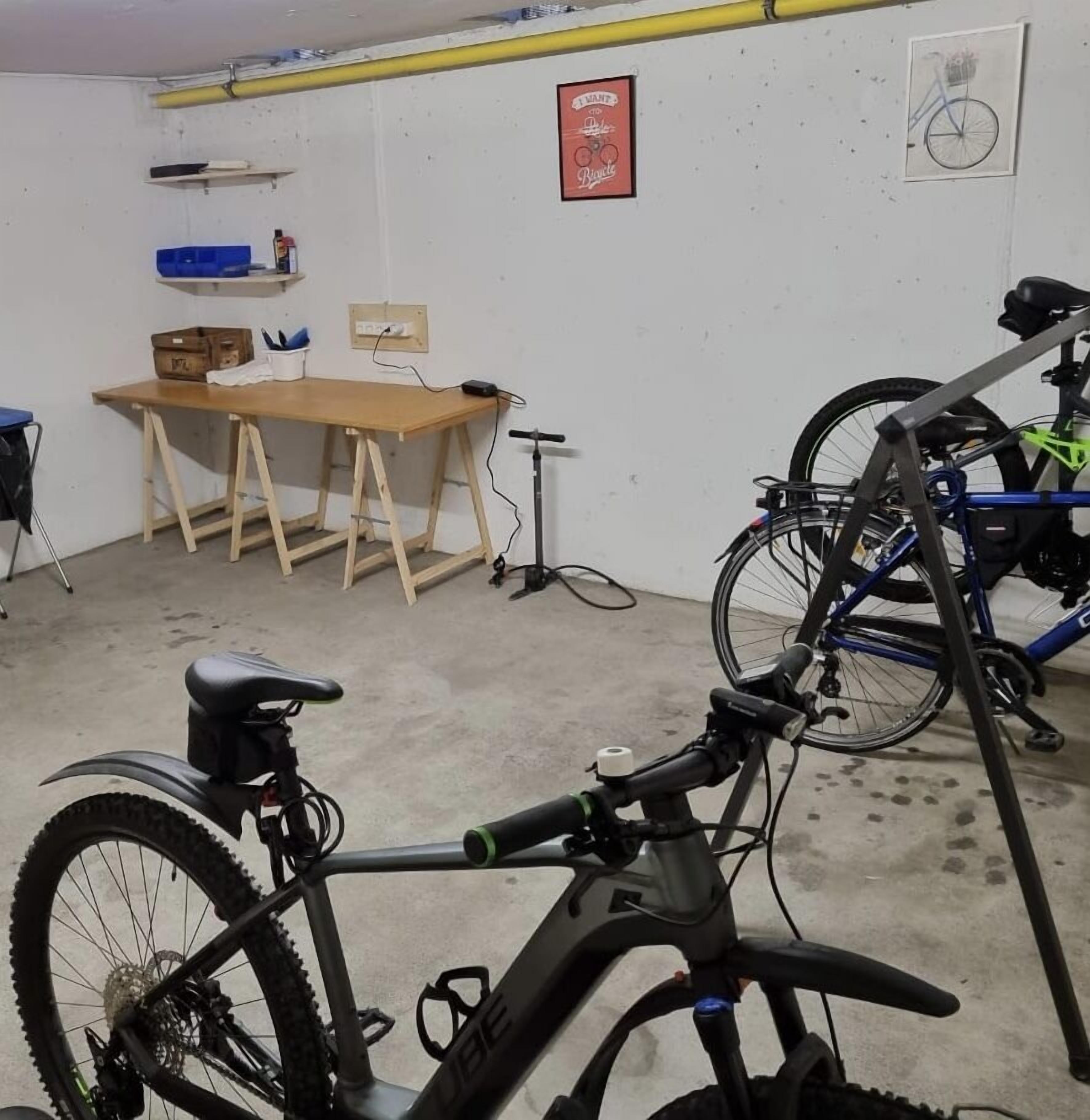 Ein Zimmer mit einem Holztisch, einem Fahrrad und einem an der Wand befestigten Schild.