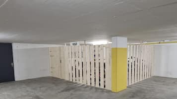 Ett parkeringsgarage med betonggolv och -väggar, träbarriärer och en gul pelare.