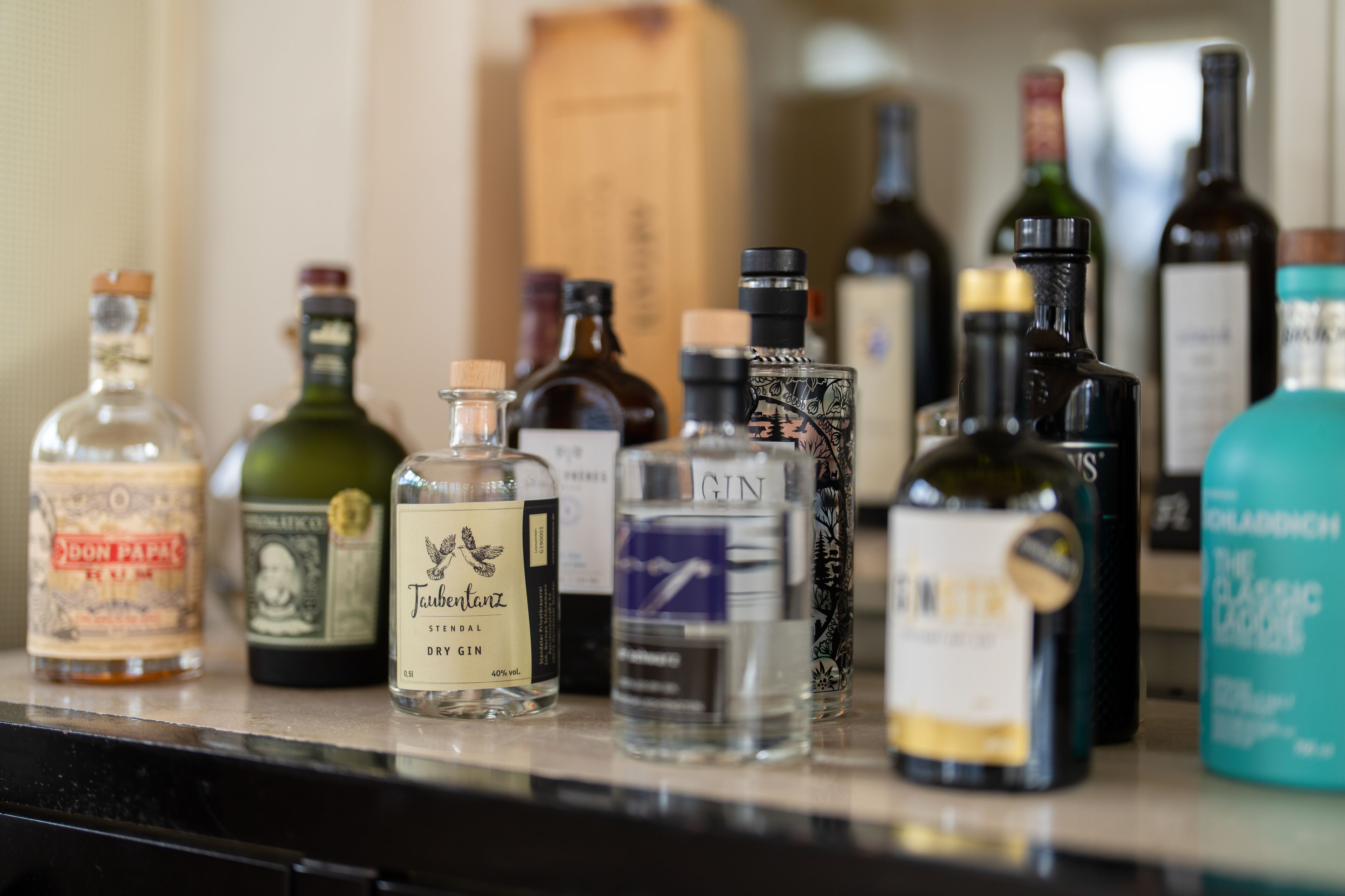 A variety of liquor bottles on a countertop.