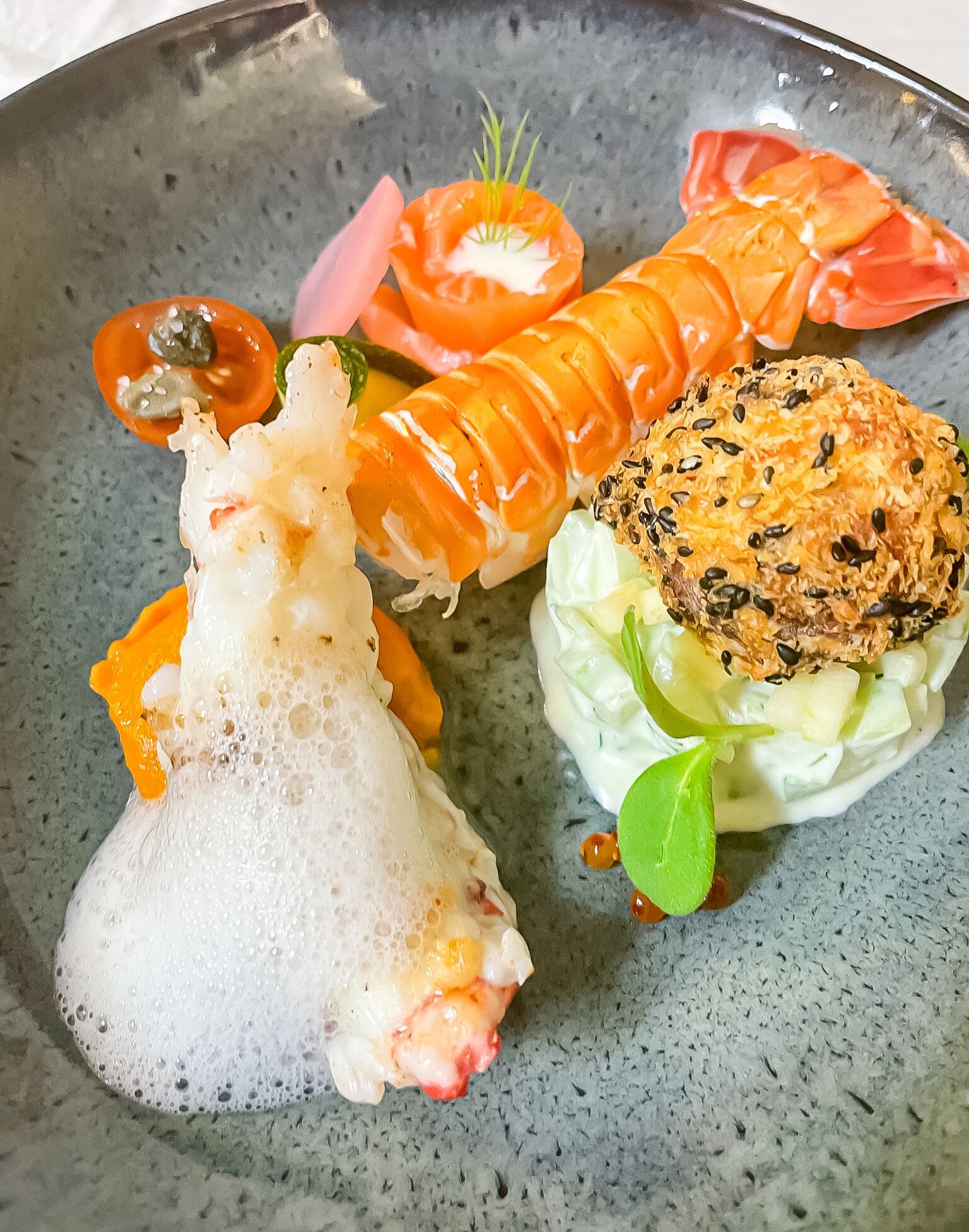 Un plato de sushi con distintos ingredientes y una sopa acompañada.