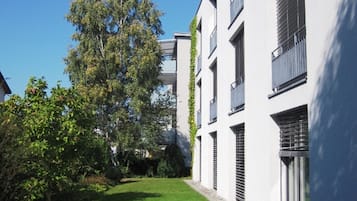 Un edificio moderno con tejado plano, amplios ventanales y un césped bien cuidado.
