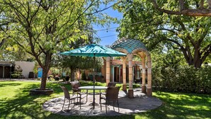 An outdoor patio area with a gazebo, a table with chairs, and a large umbrella. - Casas de Suenos Old Town Historic Inn, an Ascend Collection Hotel (Albuquerque)