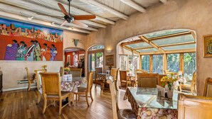 A restaurant with wooden furniture, a ceiling fan, and a mural on the wall. - Casas de Suenos Old Town Historic Inn, an Ascend Collection Hotel (Albuquerque)