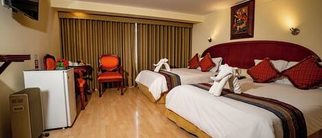 A hotel room with two beds, a desk, a chair, and a television.