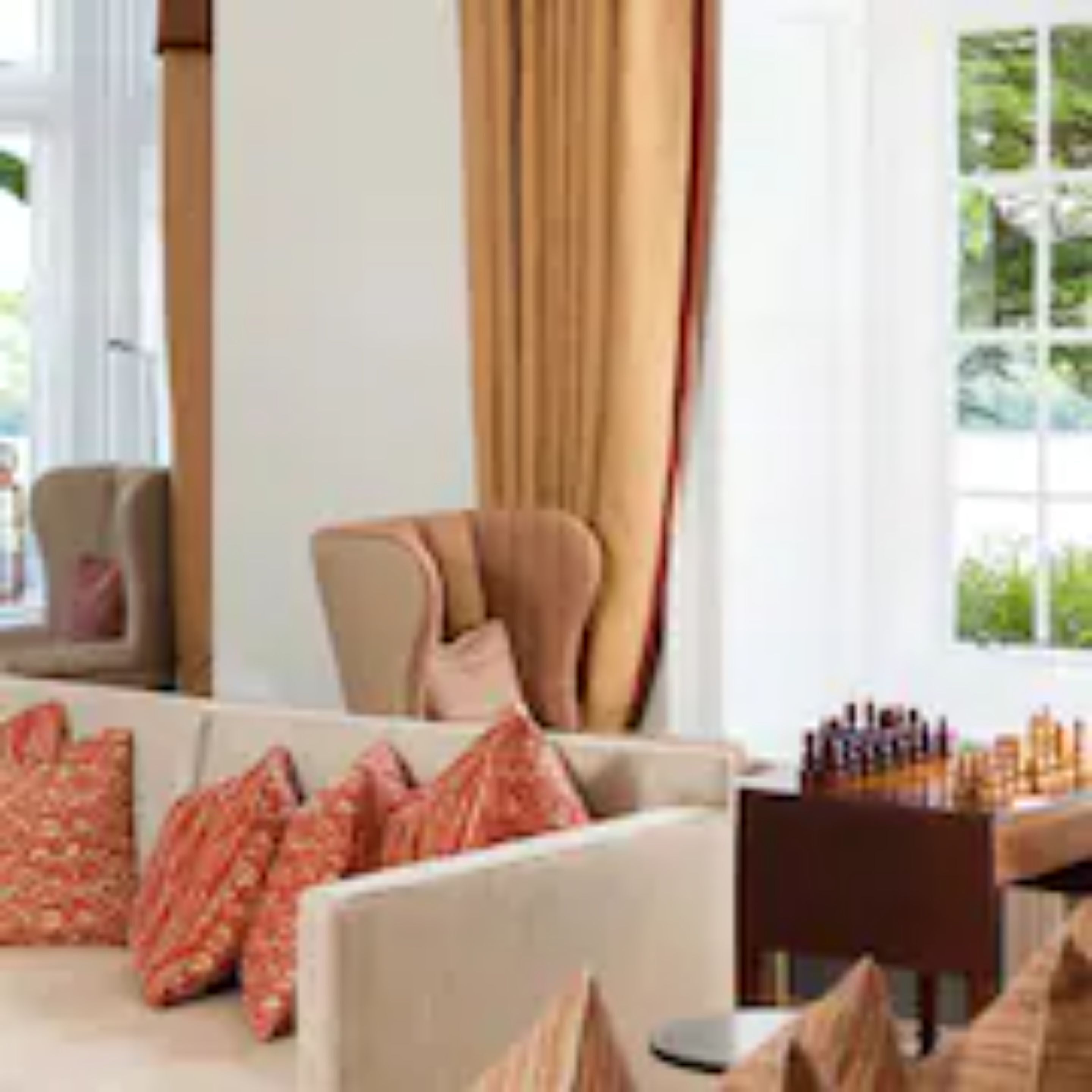 A living room with a sofa, two armchairs, a coffee table, and a side table with a lamp.