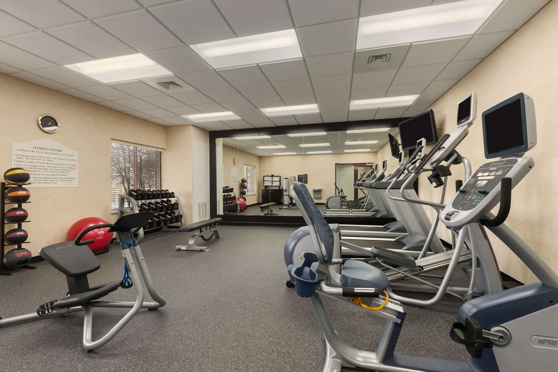 Un centre de remise en forme équipé de tapis de course, de vélos elliptiques et de poids libres.