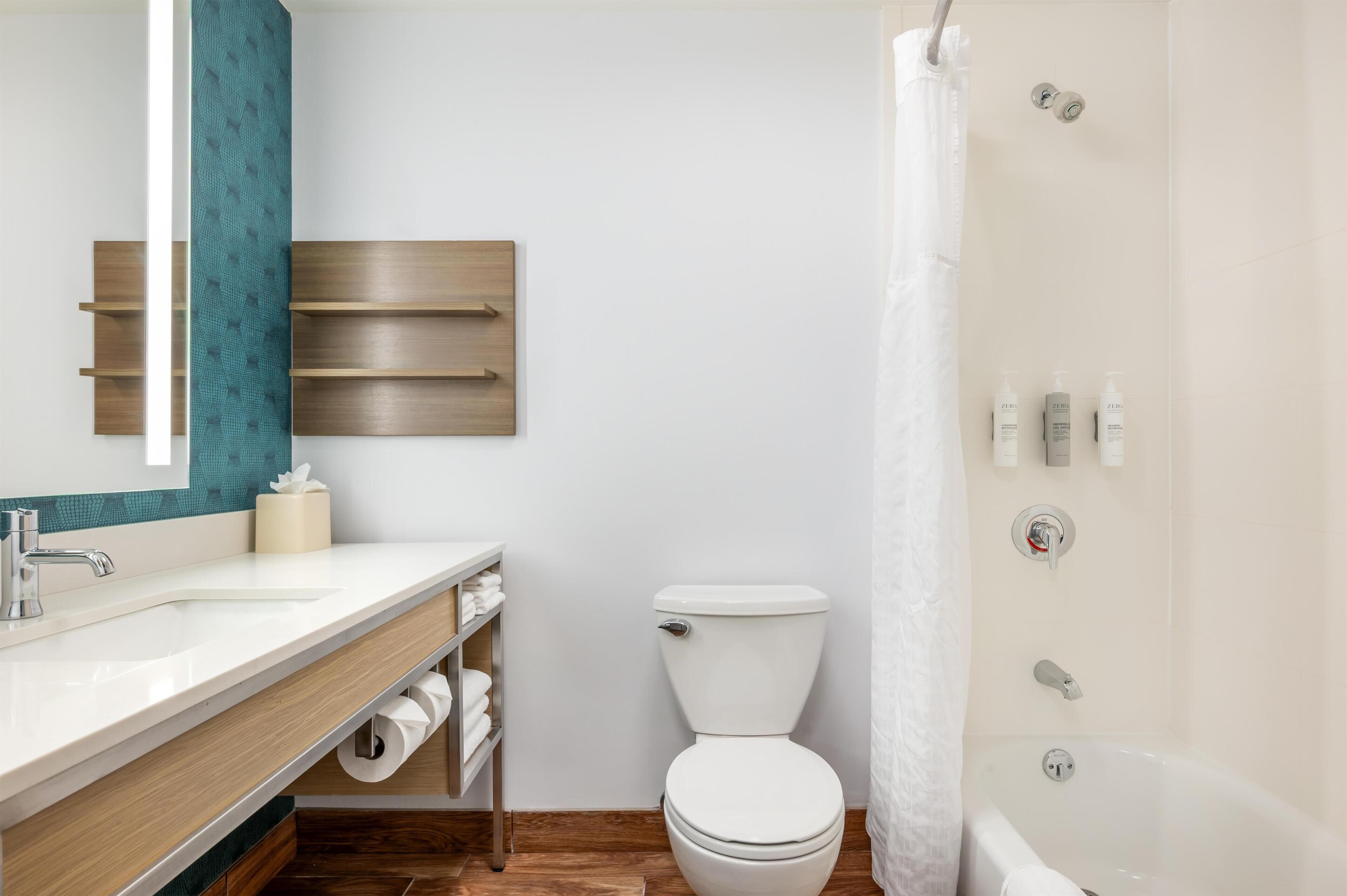 Un baño moderno con un lavamanos blanco, un inodoro y una bañera.