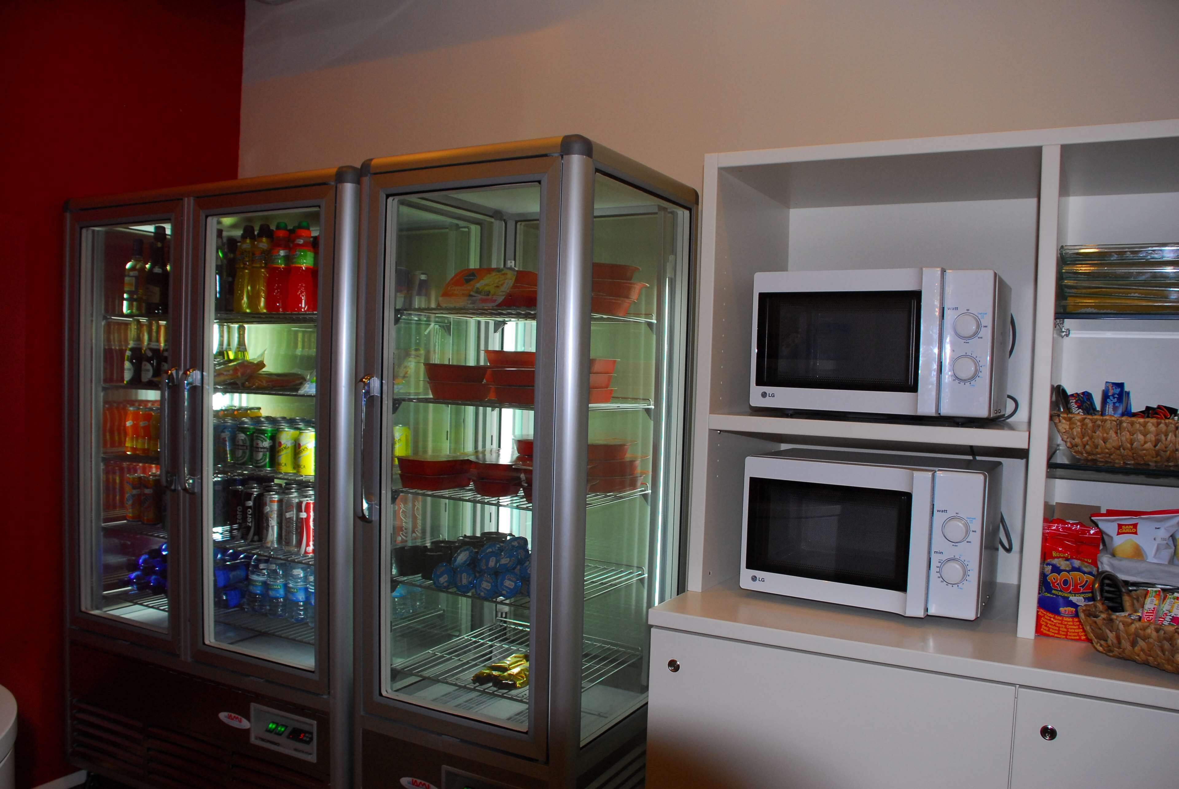 Eine Küchenzeile mit einer Mikrowelle, einem Minikühlschrank und einem Kühlschrank.