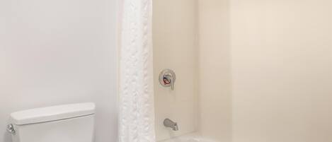 Ein Badezimmer mit Toilette, einer Duschkabine und einer Badewanne.