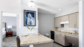 Una cocina moderna con encimeras de granito, armarios color beige y lavavajillas integrado.