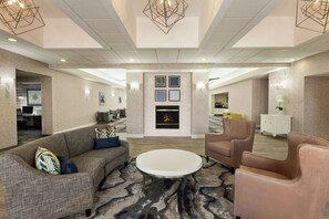 Relax in the stylish lobby, featuring a cozy seating area, fireplace, and modern lighting.