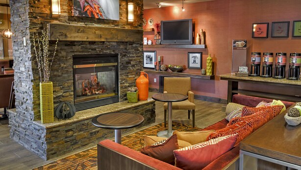 A cozy lounge area with a stone fireplace, comfortable seating, a coffee bar, and a flat-screen TV. - Hampton Inn Twin Falls Id (Twin Falls)