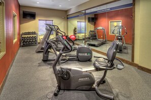 A gym with treadmills, an elliptical, and a stationary bike.