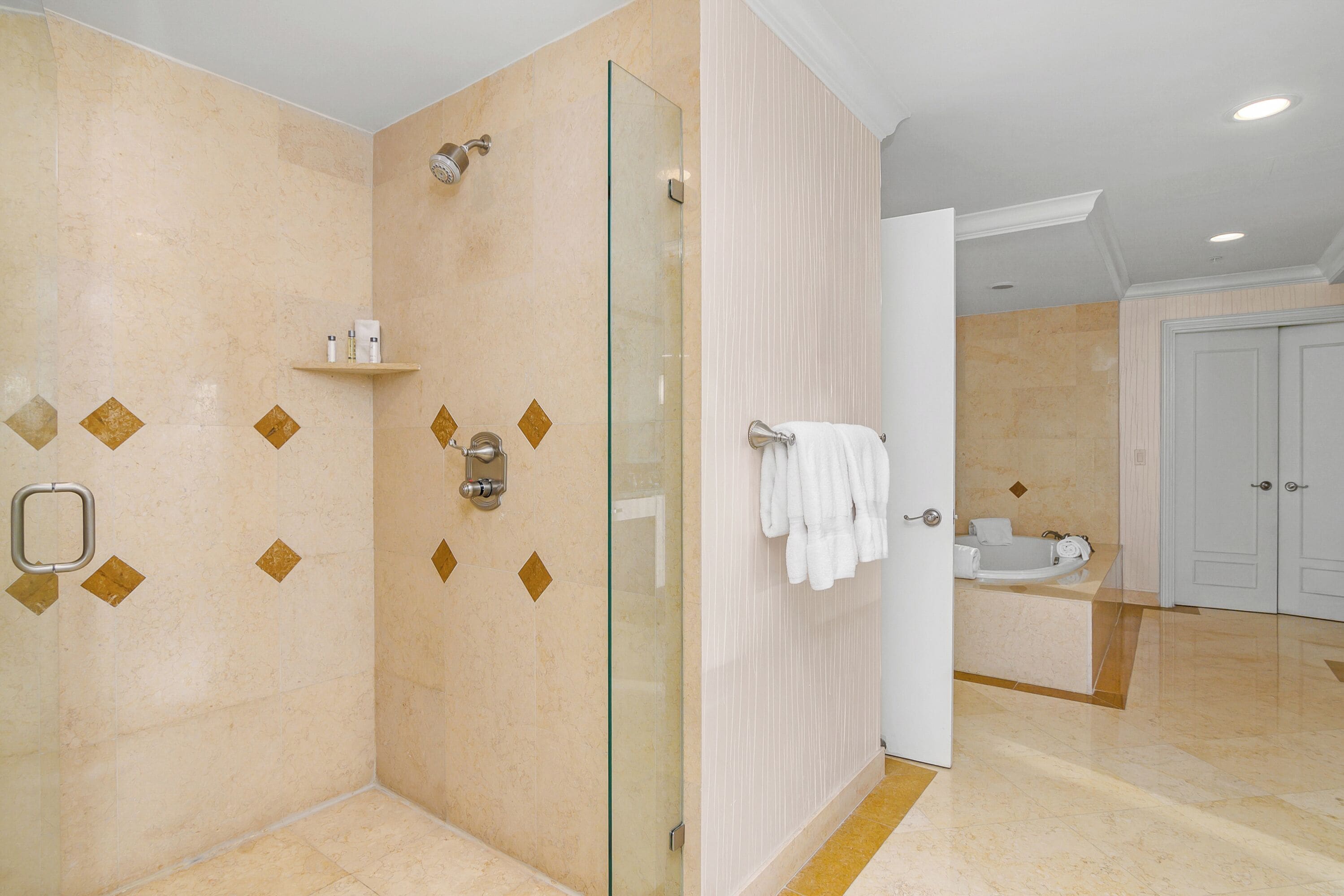 Un baño moderno con ducha envuelta en vidrio, tocador con lavamanos y un inodoro.
