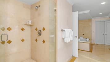 Un baño moderno con ducha envuelta en vidrio, tocador con lavamanos y un inodoro.