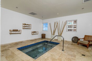 A modern living room with a white sofa, a coffee table, and a fireplace. at The Atlantic Hotel & Spa