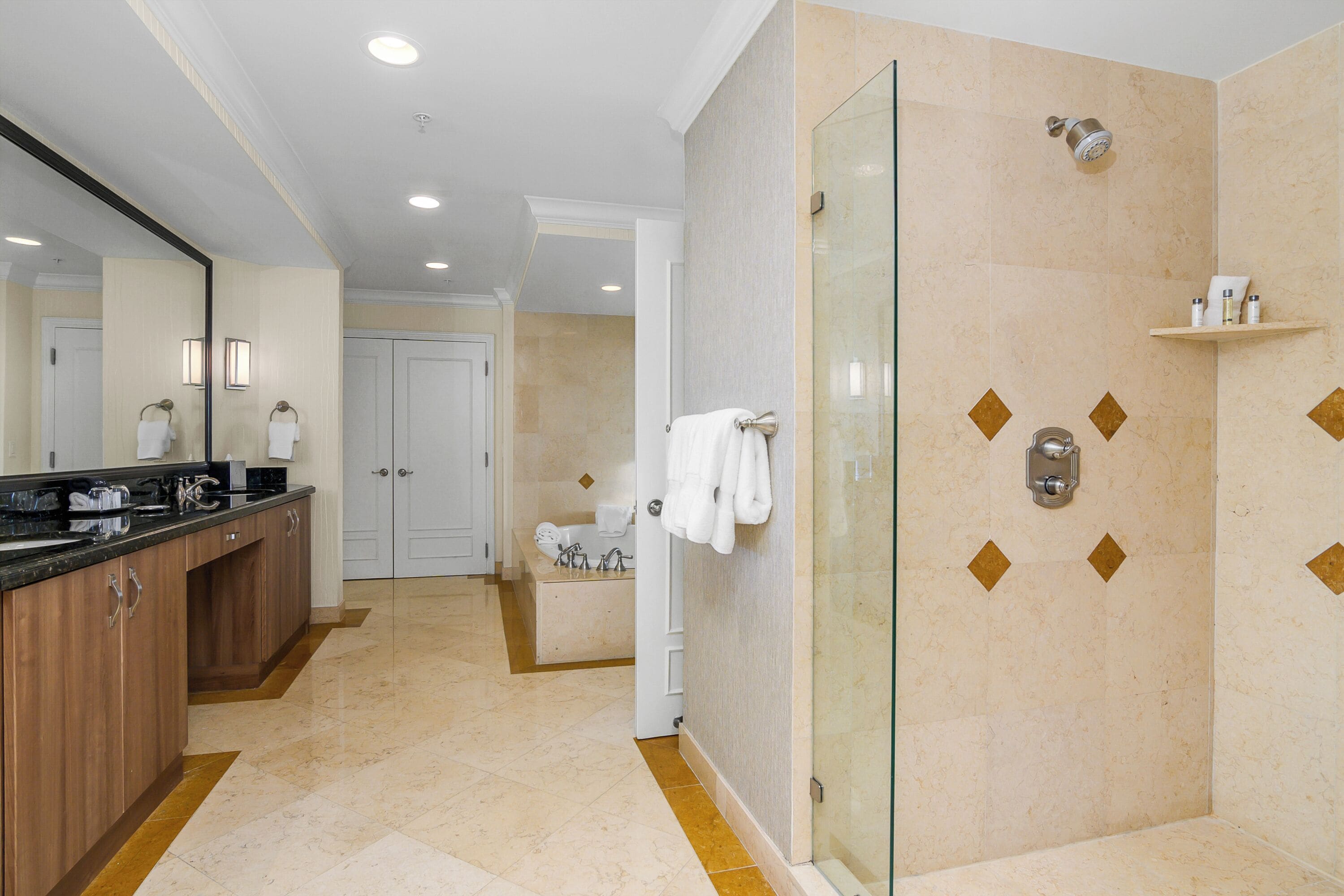 Un baño moderno con cabina de ducha de vidrio, tocador con lavamanos y espejo.