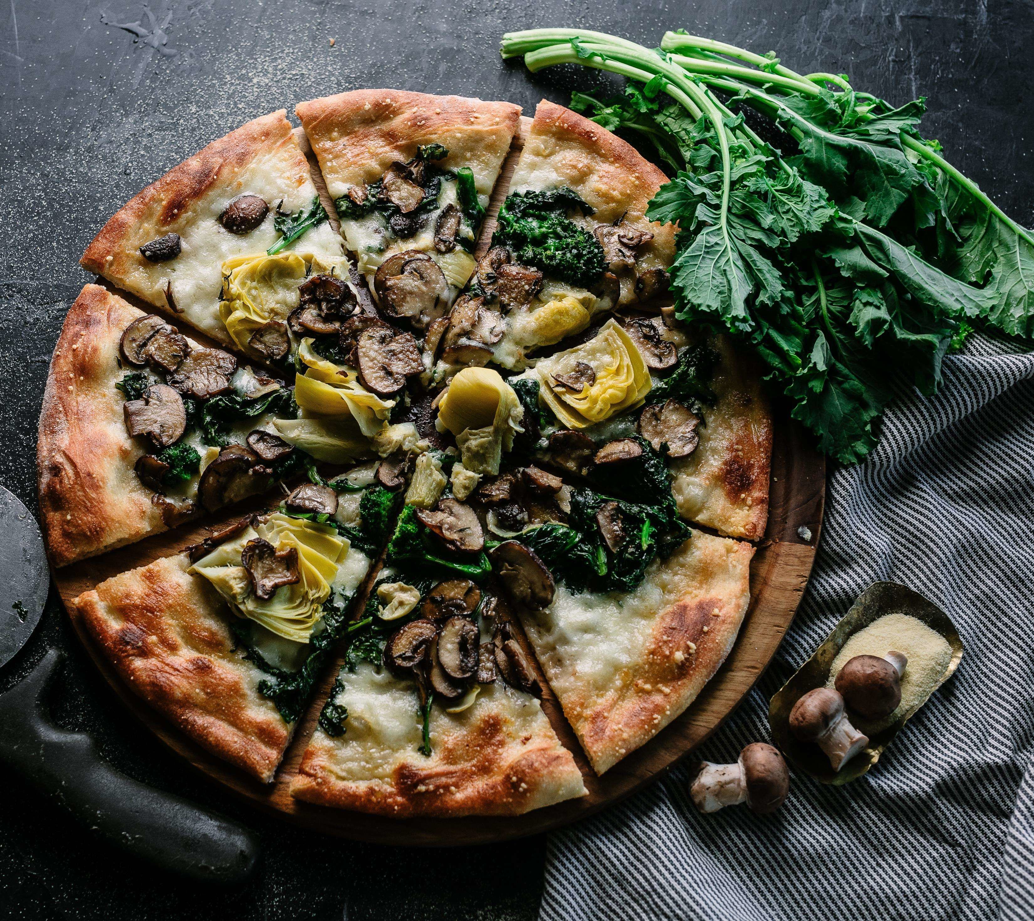 A pizza with various toppings on a wooden board.