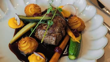 Ein Teller Essen mit gewölbtem Rand, ein Messer und ein Glas.