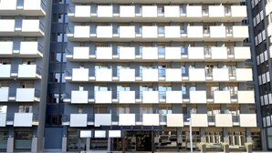 Un immeuble à plusieurs étages, doté de balcons et d’une entrée au niveau du sol.