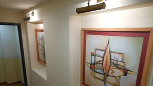 Un pasillo con pinturas abstractas en las paredes y suelo de baldosas.