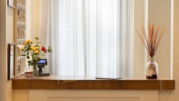 Ein Empfangsschalter mit einer Registrierkasse, einer Blumenvase und einem Reed-Diffuser.