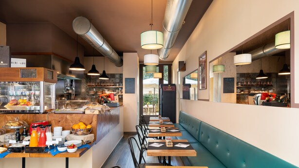 A restaurant with a long counter, seating area, and a buffet. - Hotel Cimabue (Florence)