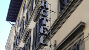 A hotel facade with a sign reading "HOTEL" and a visible entrance door. - Hotel Cimabue (Florence)