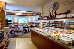 A buffet area with various food options and a seating area with tables and chairs.