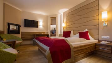 Ein Hotelzimmer mit Bett, Nachttischen, einem Fernseher und einer Sitzecke mit Stühlen.