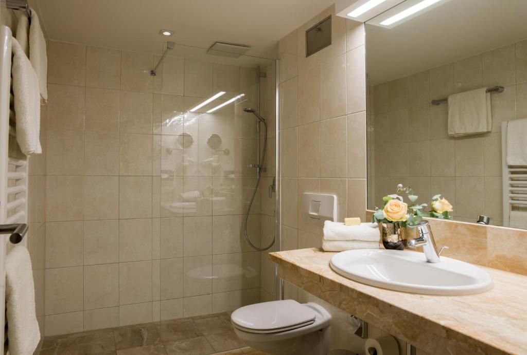 Une salle de bain moderne équipée d’une douche, de toilettes et d’un lavabo.