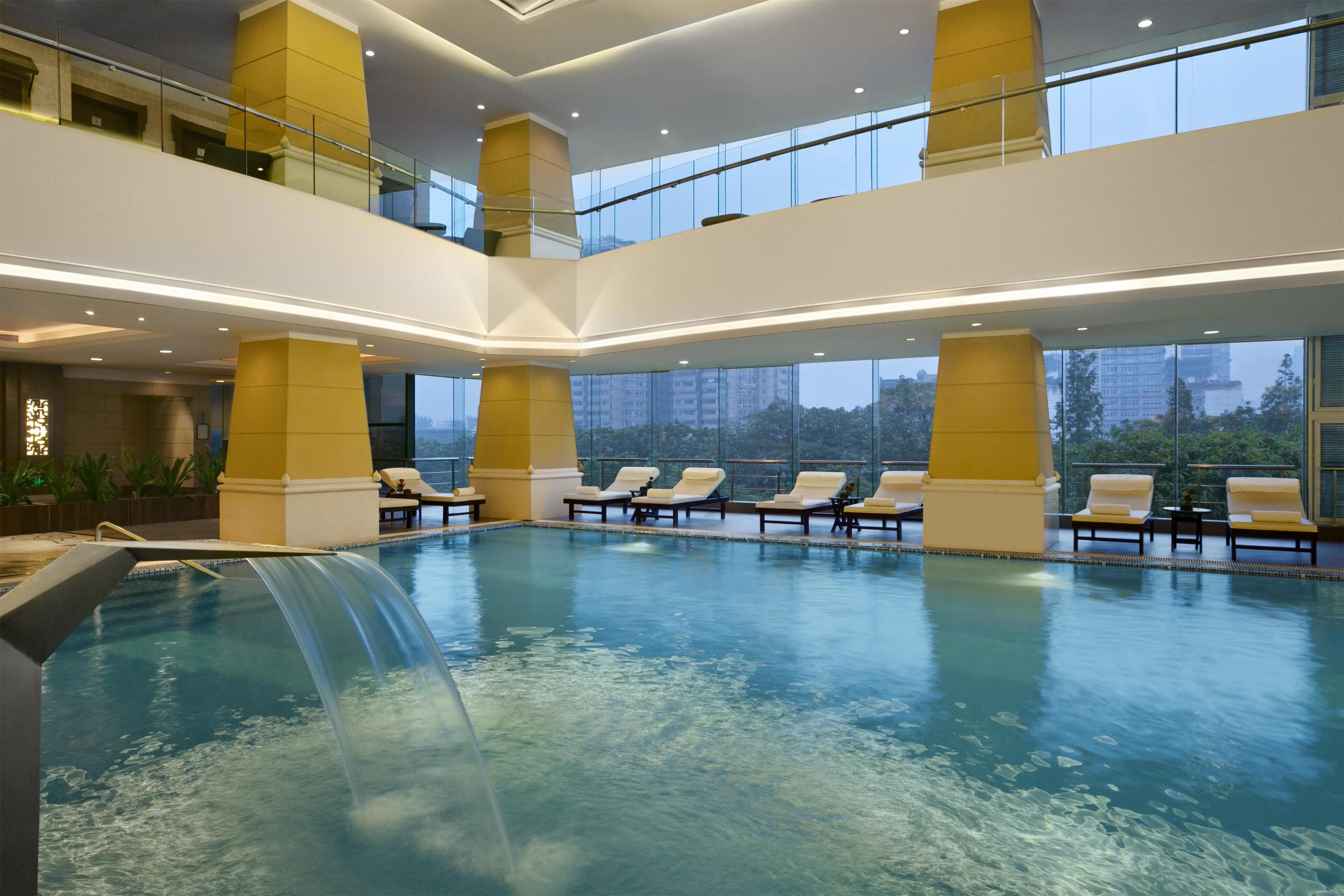 Una piscina techada, sillones reclinables de piscina