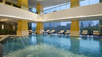 Una piscina techada, sillones reclinables de piscina