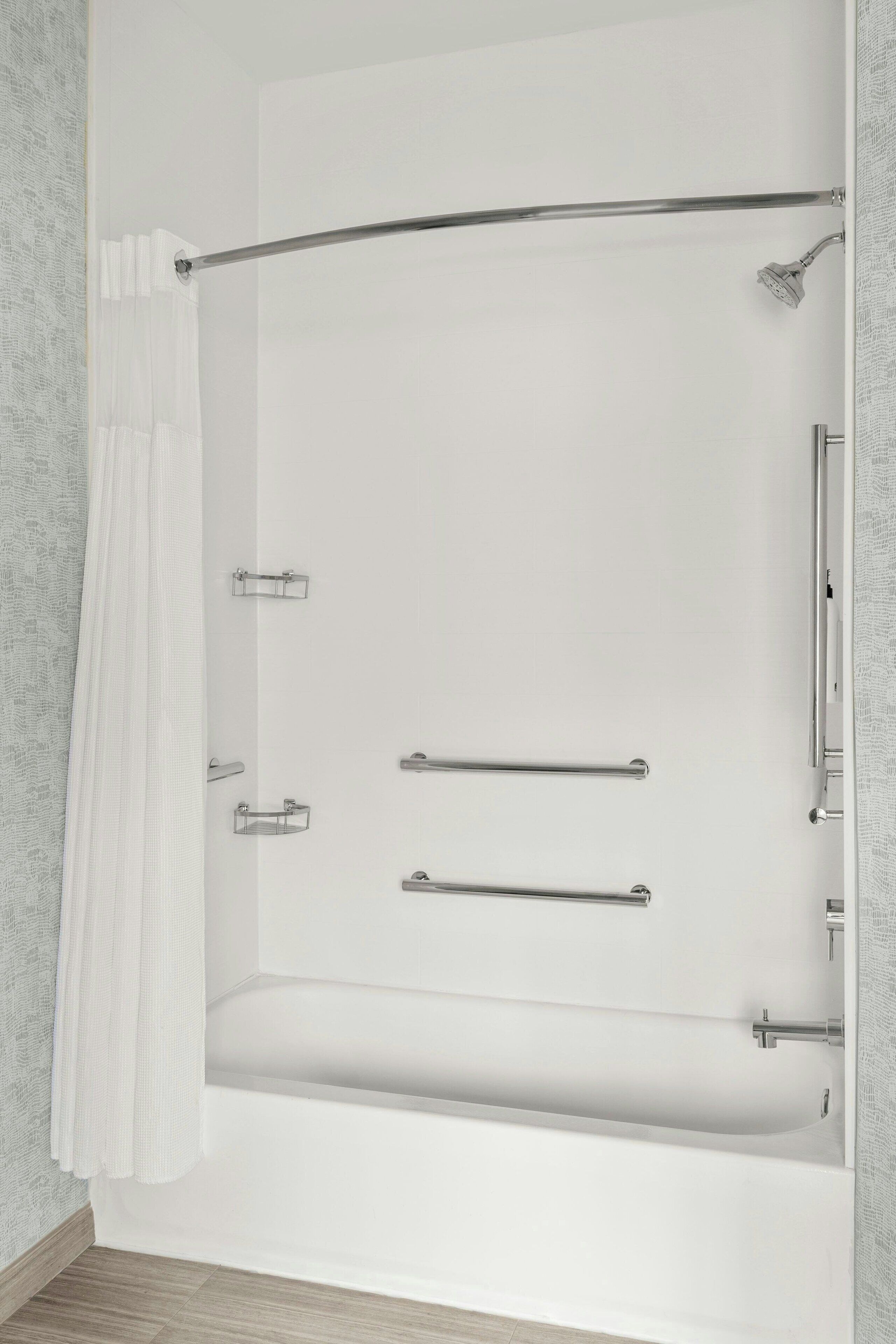Un baño moderno con bañera, ducha y un perchero para toallas.