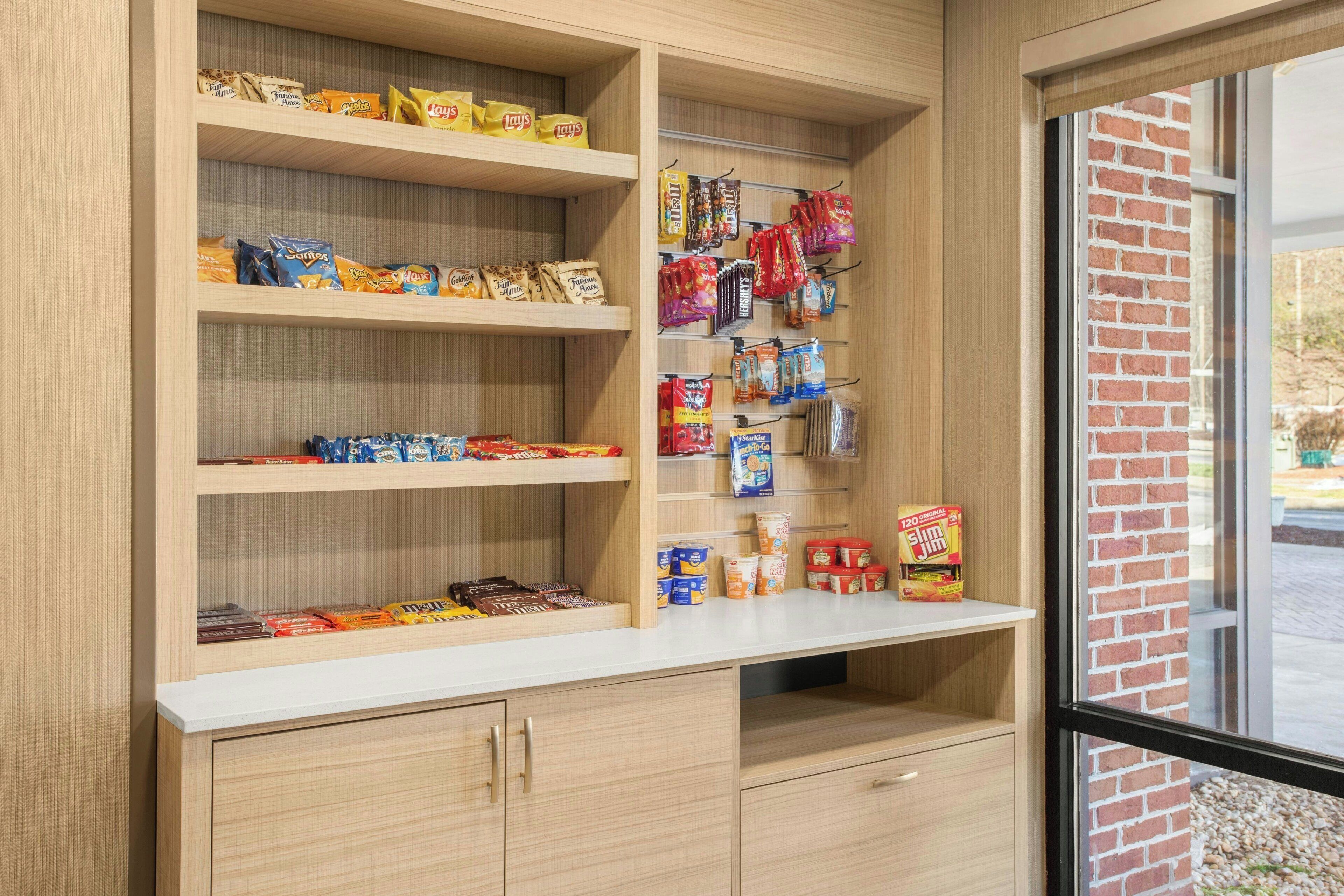 A snack display with various packaged foods and a window view.