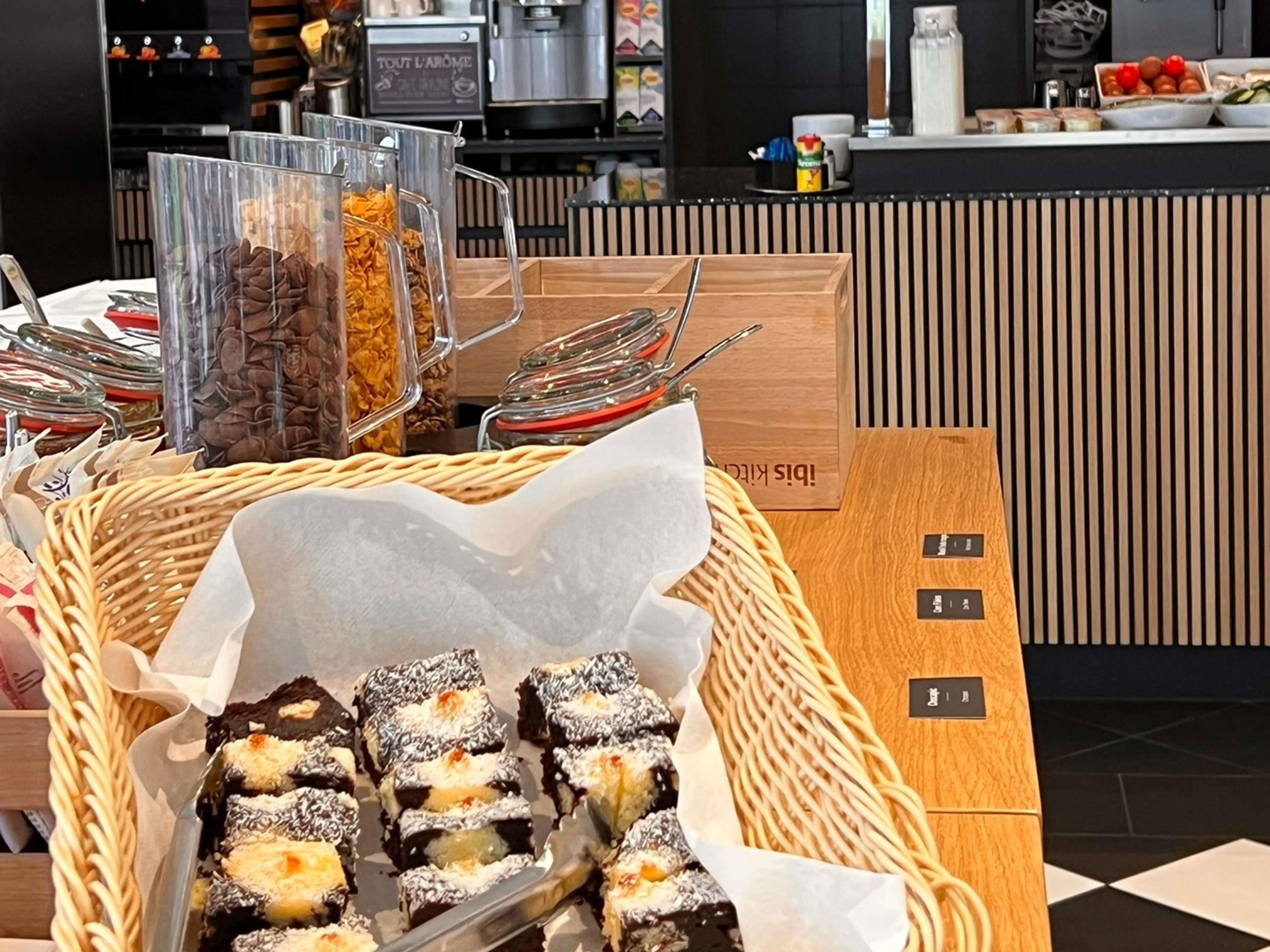 Un espace buffet proposant divers plats, une machine à café et un comptoir avec un panneau indicateur.