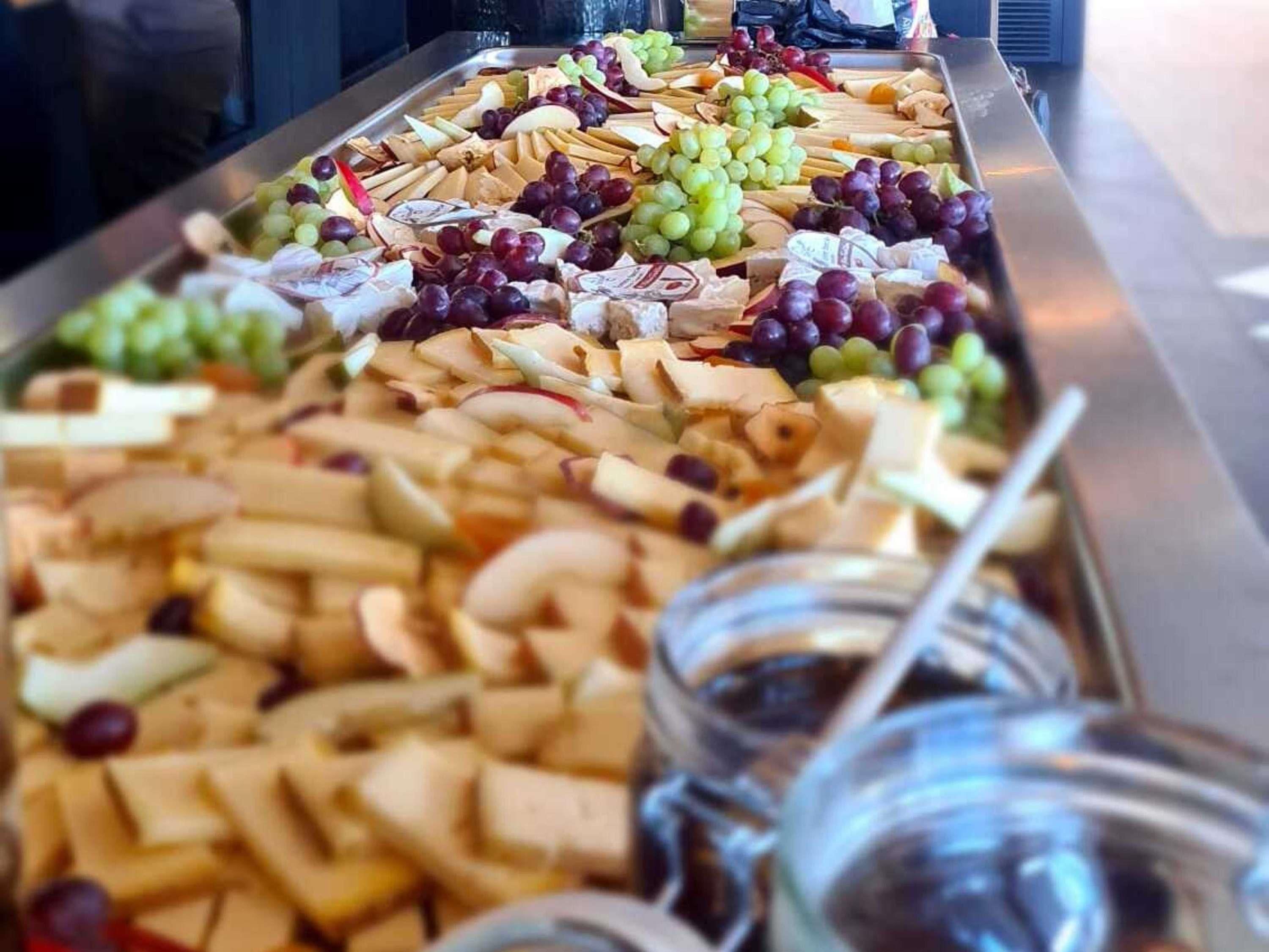 Ein Buffet mit verschiedenen Käsesorten, Obst und Nüssen.