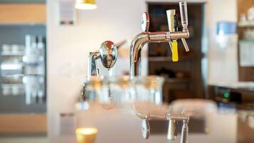 Une cuisine moderne dotée d’un robinet en acier inoxydable et d’un plan de travail en verre.