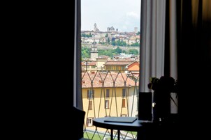 Vista dalla finestra su una città con edifici storici e una torre dell'orologio.