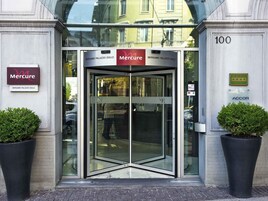 Ingresso con porta girevole di un hotel, con insegne che riportano 'Mercure Bergamo Palazzo Dolci' e 'Albergo Hotel'.