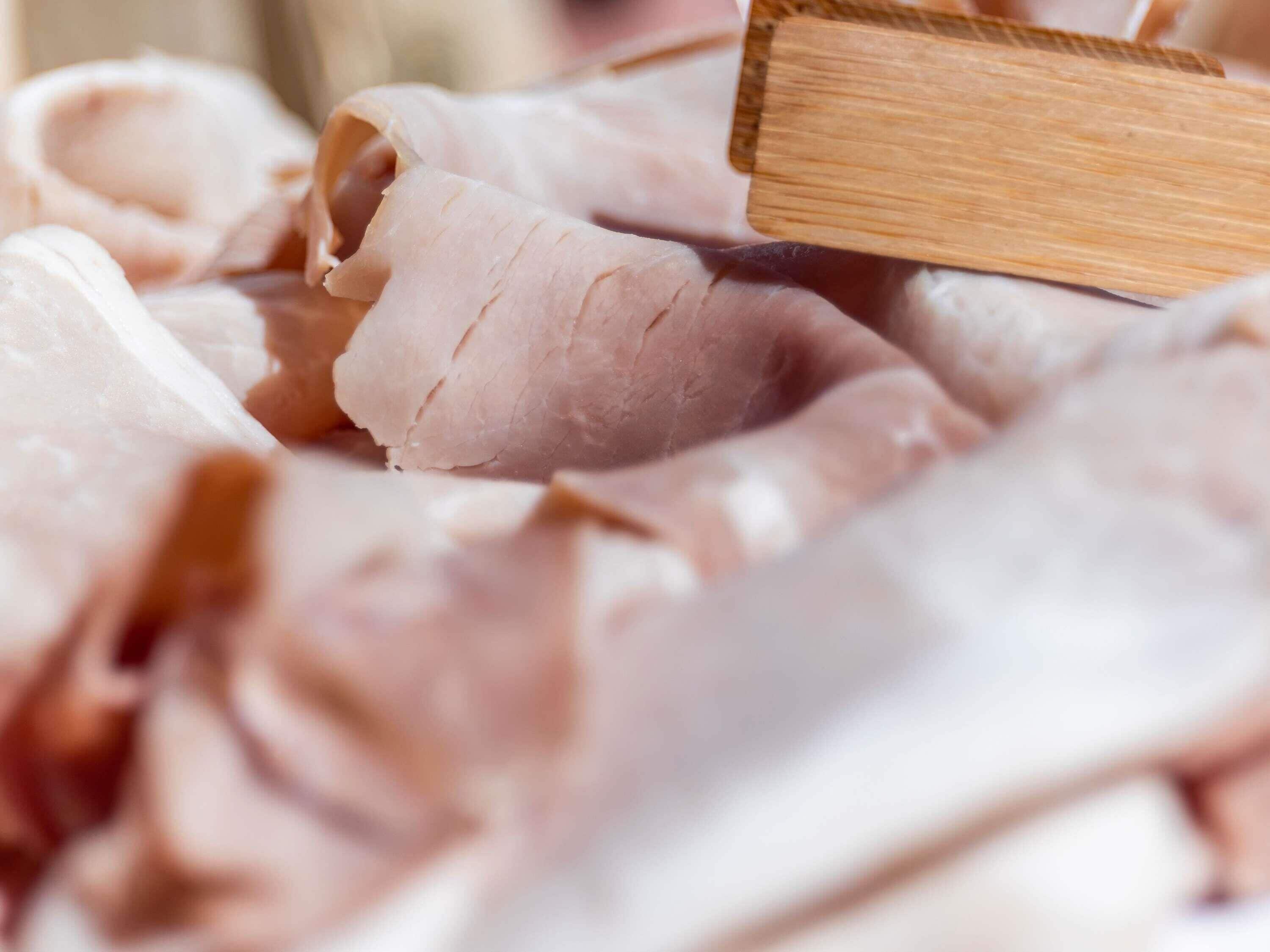 Primer plano de carne cortada sobre una tabla de madera.