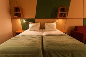 A double bed with green bedding, two bedside tables, and a red chair. - Savoy Hotel Amsterdam (Amsterdam)