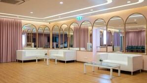 A modern lobby with white sofas, glass tables, and mirrored walls. - Bangkok Rama Hotel (Bangkok)