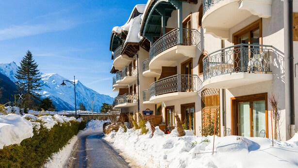 A hotel with multiple balconies, a snow-covered path, and a mountain in the background. - Residence  Le Cristal d'Argentière (Chamonix-Mont-Blanc)