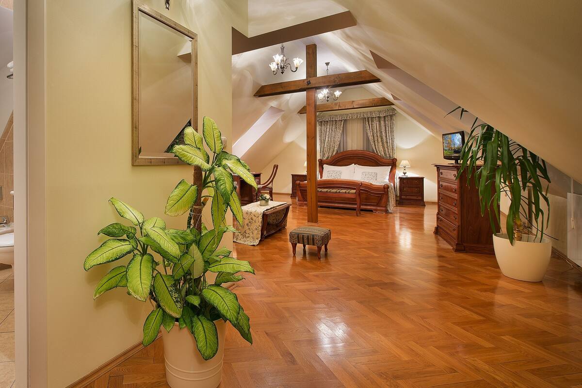 A bedroom with a wooden bed, a nightstand, a dresser, and a television.