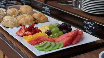 A breakfast buffet with various pastries and fresh fruit.