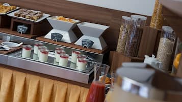 A buffet with various food items including desserts, fruits, and grains.