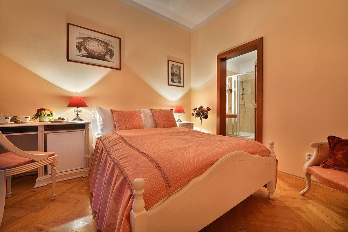 A bedroom with a bed, a desk, a chair, and a dresser.