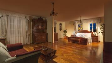 Un salón amplio con un gran aparador de madera, un sofá, una mesa de centro y una cama con cabecero de madera.