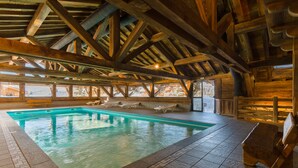 An indoor swimming pool with wooden beams and tiled flooring. - Residence Lagrange Vacances le Village des Lapons (Hauteluce)